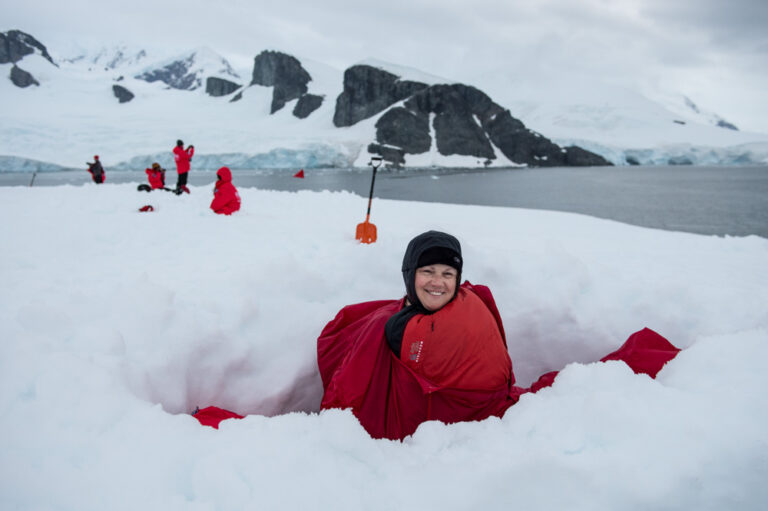 Camping Gruppe in der Antarktis mit einer Passagierin in einem Biwak im Schnee